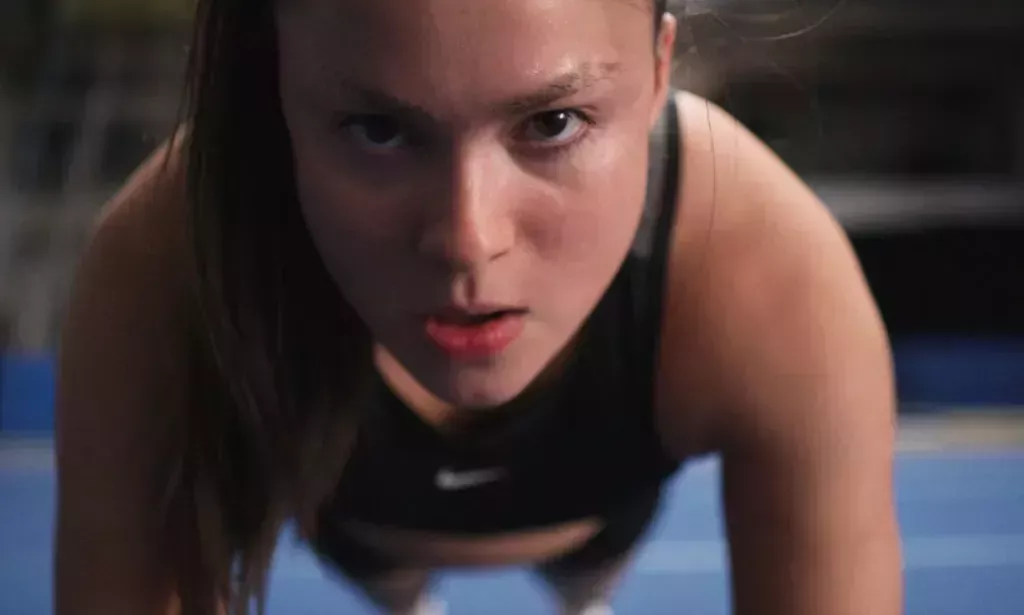 A still from the trailer of Backspot featuring Devery Jacobs as Riley doing a push up