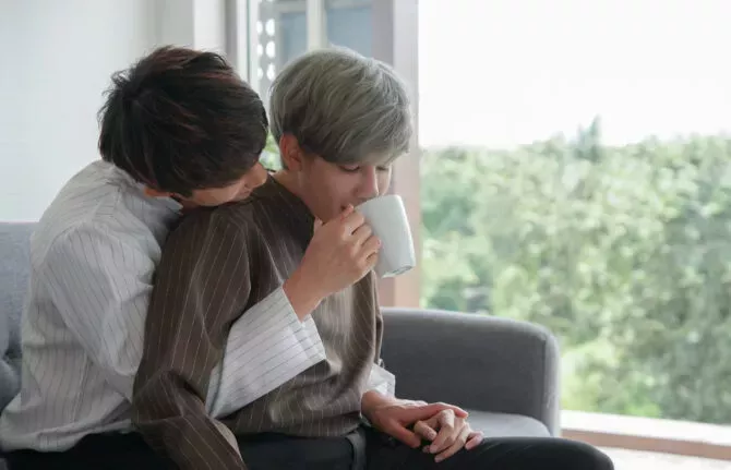 lovers hugging drinking cup of coffee together in the morning