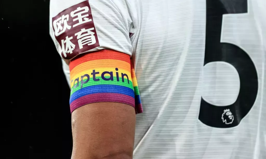 A football player wearing an LGBTQ+ armband.