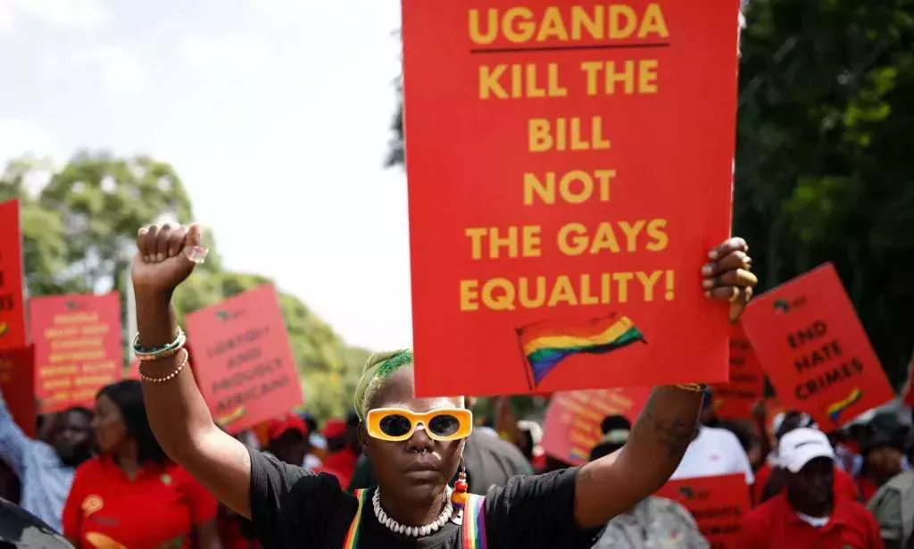 DeLovie Kwagala pictured holding a sign that says "Uganda Kill the bill not the gays equality!".