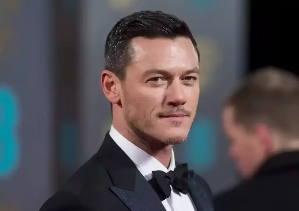 Luke Evans en un esmoquin, mirando a su derecha