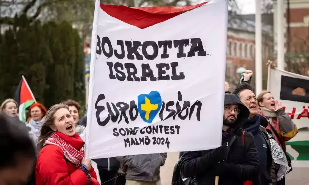 Participants hold up flags and placards during a demonstration outside the City Hall in Malmö, Sweden on April 10, 2024 in connection with the municipal board's consideration of a citizens' proposal to stop Israel's participation in the Eurovision Song Contest. The demo was organised by the citizens' initiative 'No Eurovision in Malmö with Israel's participation'. (Photo by Johan NILSSON / TT News Agency / AFP) / Sweden OUT (Photo by JOHAN NILSSON/TT News Agency/AFP via Getty Images)