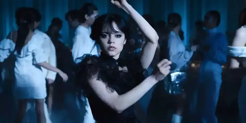 Una escena de la serie Wednesday de Netflix mostrando a la actriz Jenna Ortega como Wednesday Addams vestida con un vestido negro y en una pose de baile